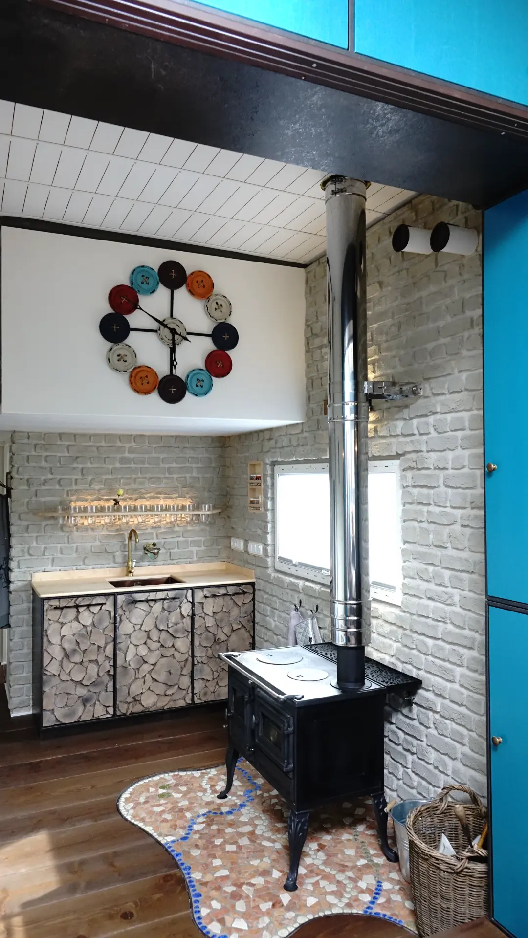 Küche mit hochwertigen Materialien - Backsteinwand, Holzarbeitsplatte und Kaminofen